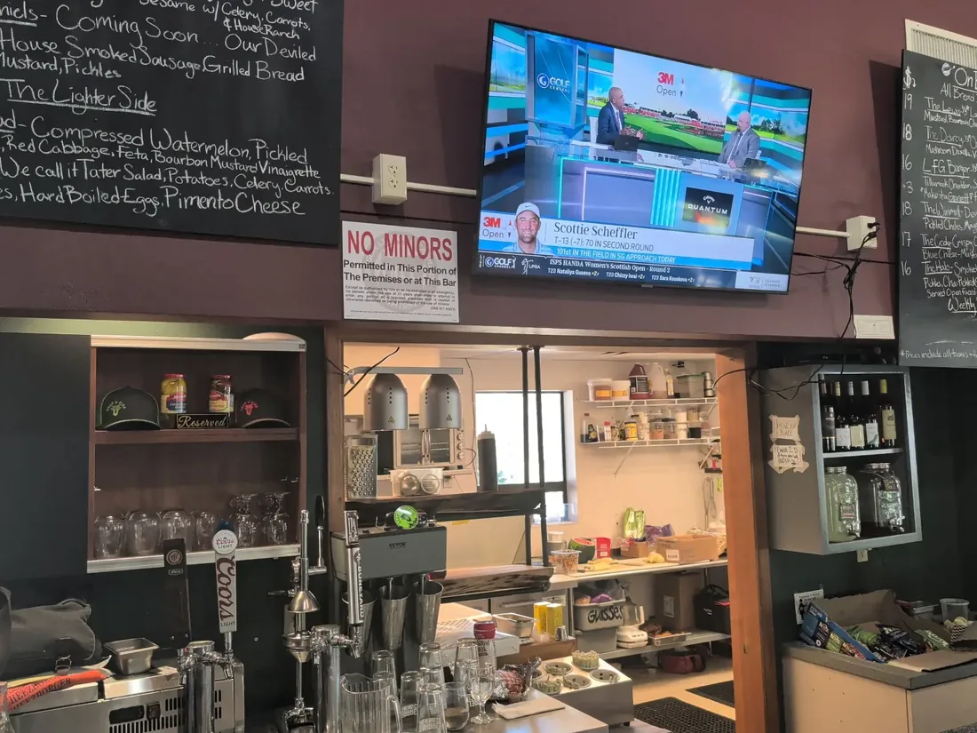 Behind the bar at Salt & Fire Meat Co. — kitchen, taps, and the menu boards
